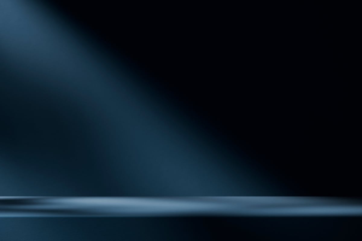 Dark minimal product stage with dramatic light and shadow
