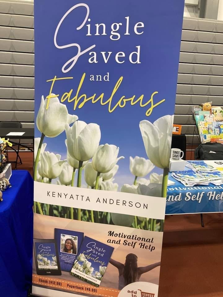 Book cover for Single Saved and Fabulous by Kenyatta Anderson featuring white tulips against a blue sky background displayed at a book event